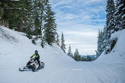 a man riding a snowboard down a snow covered slope