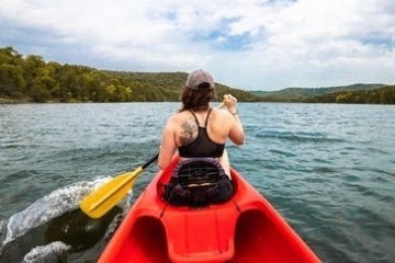 a person riding on the back of a boat in a body of water