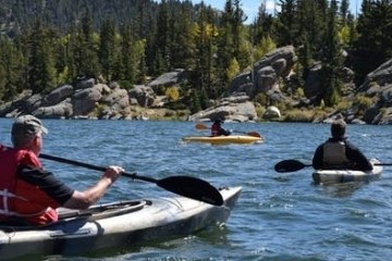 a man riding on the back of a boat in the water